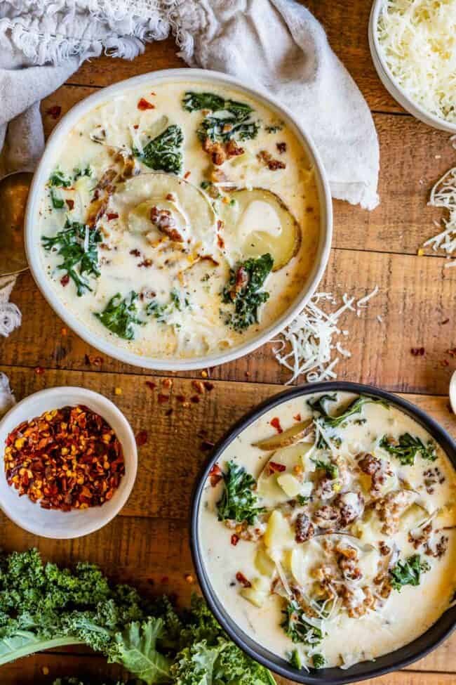 creamy zuppa toscana soup with chilli flakes served in white and black bowls