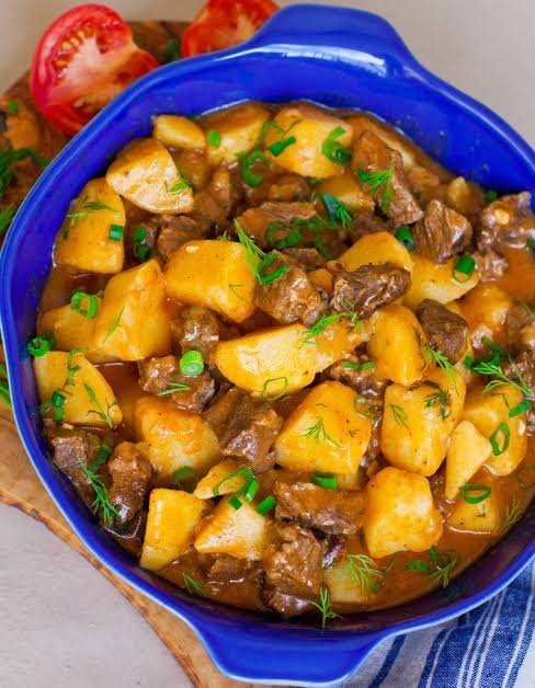 beef and potatoes stew in a blue bowl