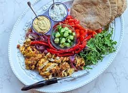 Delicious sheet pan chicken shawarma homemade served with fresh salad and pita bread