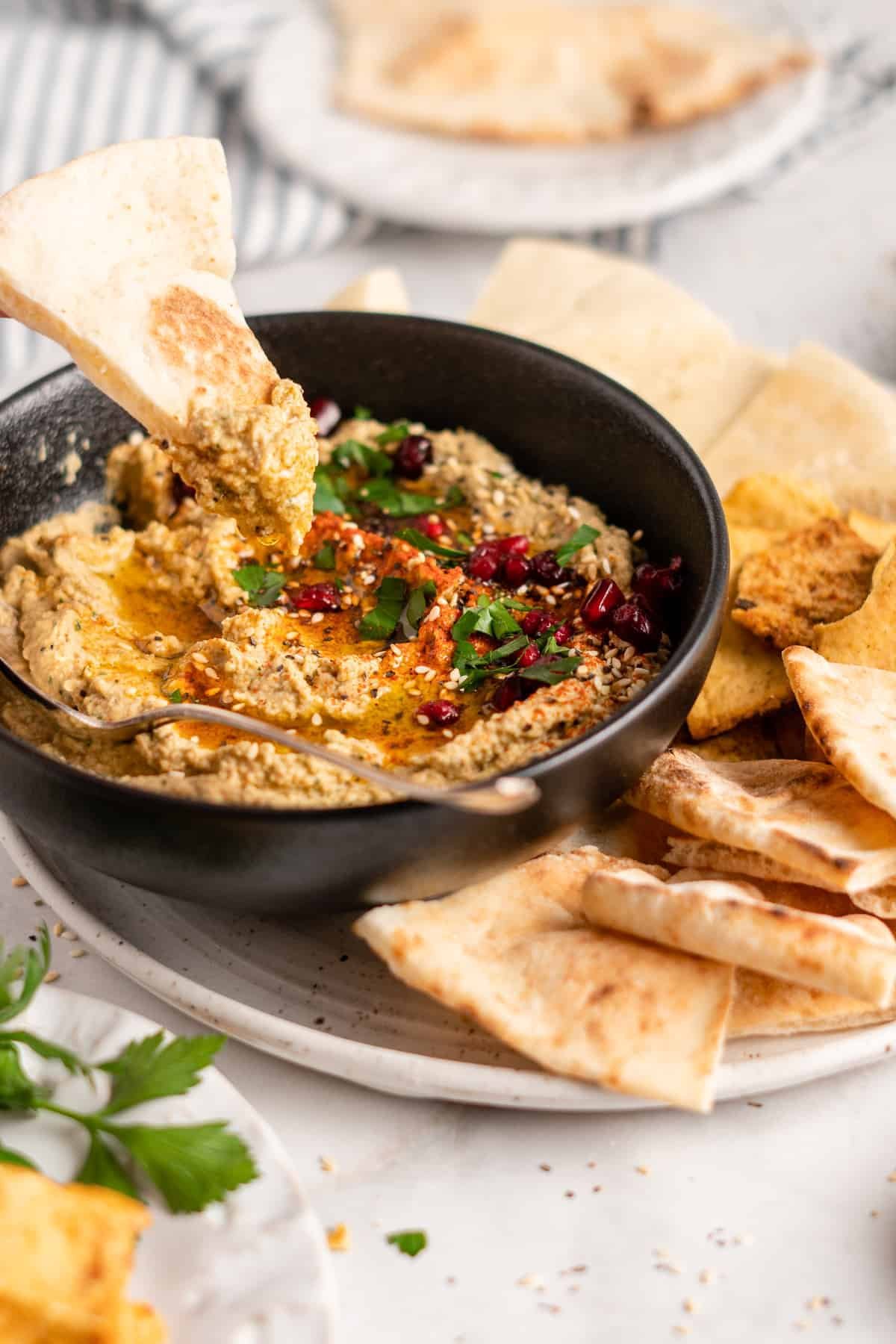 easy baba ganoush dip with naan bread served in a black round bowl