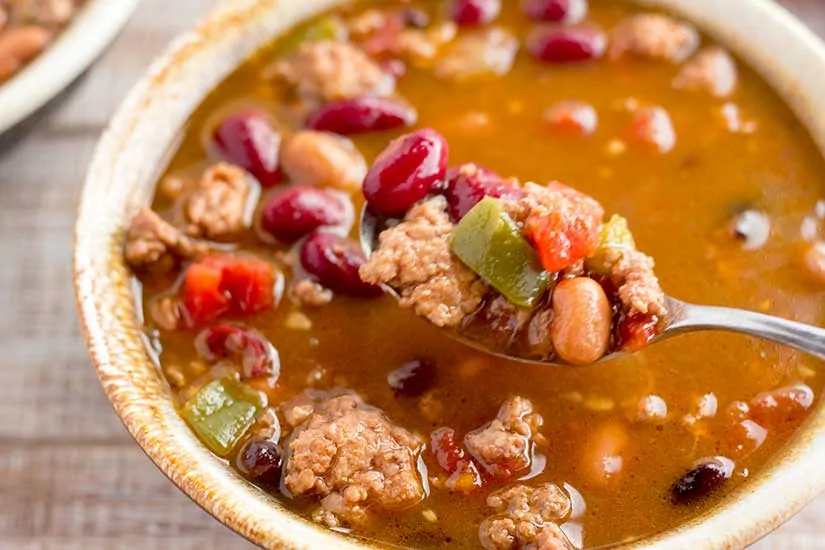 Easy Instant pot turkey chilli recipe ready in 40 minutes filled with lots of red beans and served in a light brown bowl.