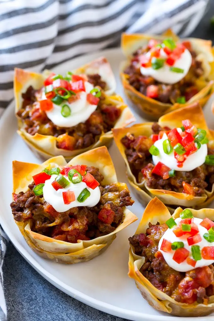 Easy snacks for any occasions, mini beef taco cups served on a plate with white and blue cloth in the background