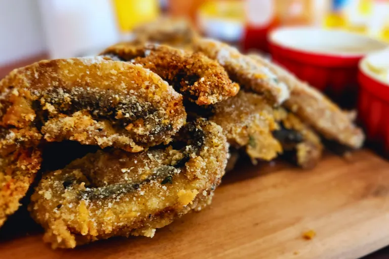 upclose homemade crumbed mushrooms served on a wooden serving board