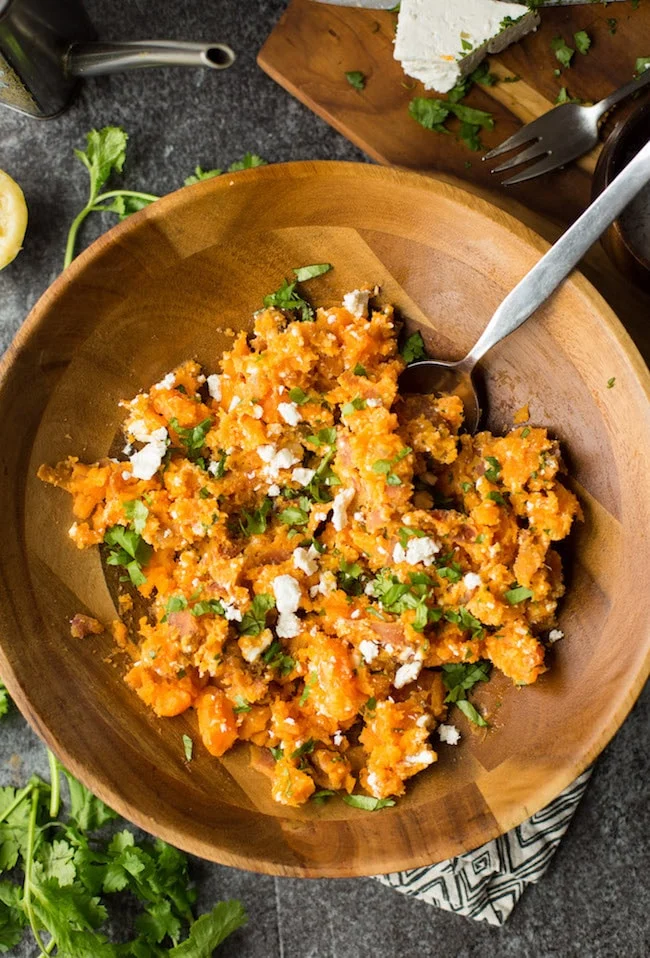 Sweet potato mash with lemon and feta cheese in a wooden bowl