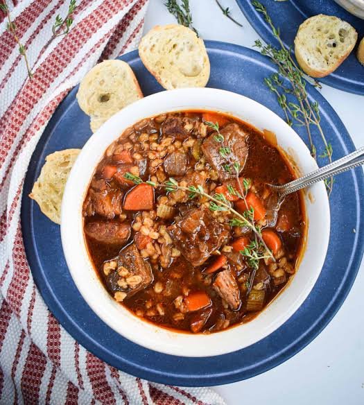 Instant pot beef barley soup in a round white bowl 