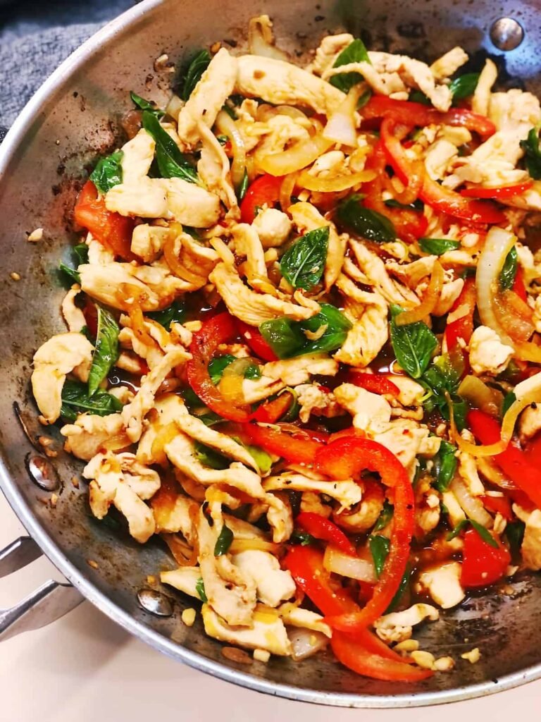 quick chicken stir fry with red peppers and basil for busy nights cooked in a skillet