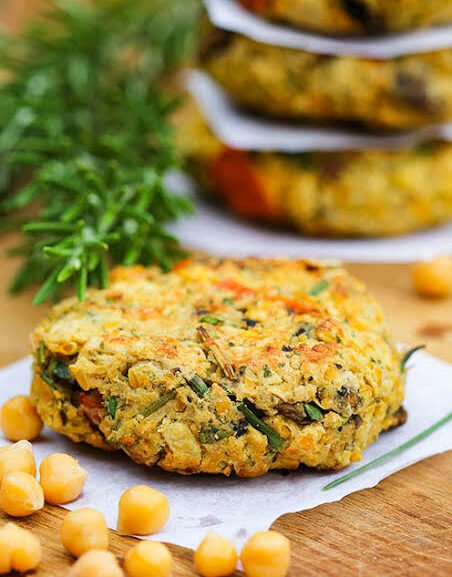 Easy homemade chickpea burger pattie on wooden board with whole chickpeas